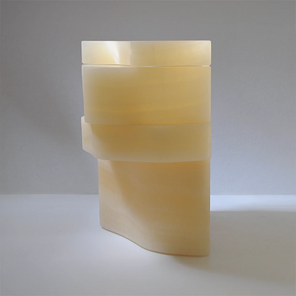 Rear three-quarter view of the closed White Moth Nightstand showing its asymmetrical onyx silhouette