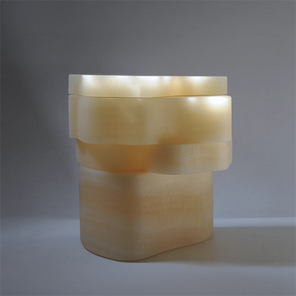 Three-quarter view of the closed White Moth Nightstand by Panorammma in softly illuminated white onyx
