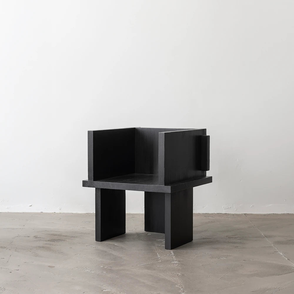 Three-quarter view of the Itooraba Chair Black by Sizar Alexis, featuring burned solid pine and a geometric architectural construction.