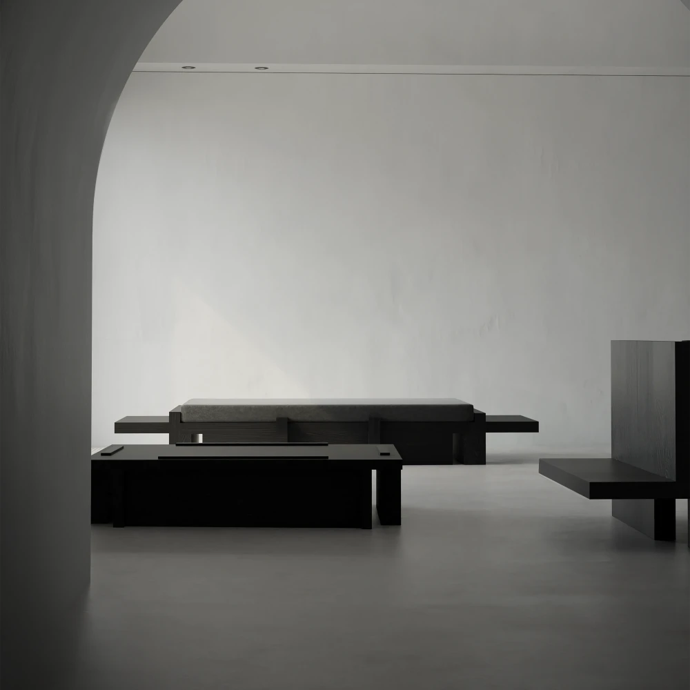 Itooraba Coffee Table by Sizar Alexis viewed through an archway within a minimalist interior furnished with coordinating black pieces.