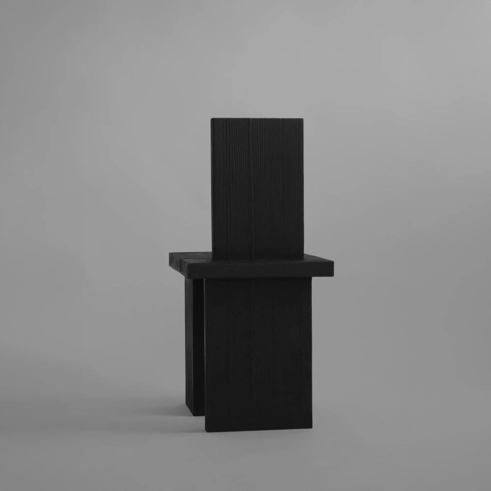 Rear view of the Itooraba Chair by Sizar Alexis, featuring a tall rectangular backrest and asymmetric burned pine slab legs.