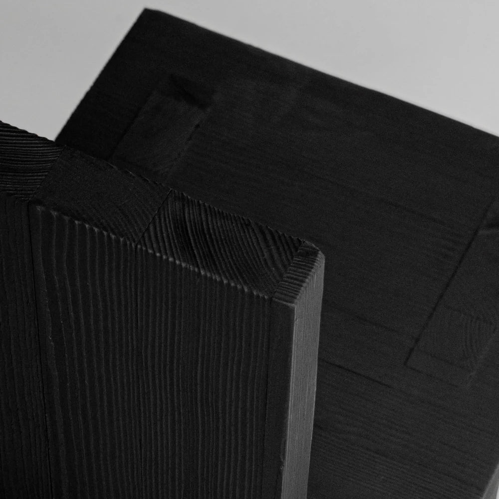 Close-up of the Itooraba Chair by Sizar Alexis, revealing the burned pine grain and intersecting seat, backrest and leg panels.