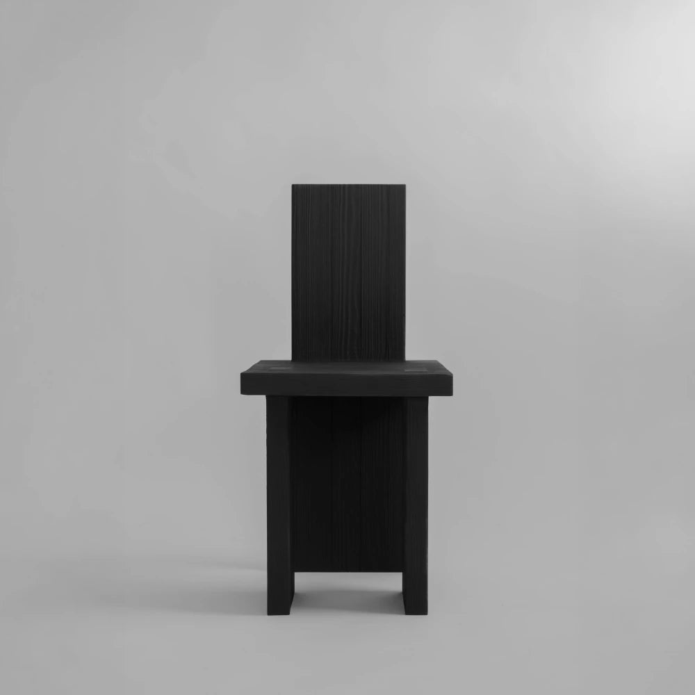 Front view of the Itooraba Chair by Sizar Alexis, emphasizing its narrow silhouette and architectural burned pine construction.
