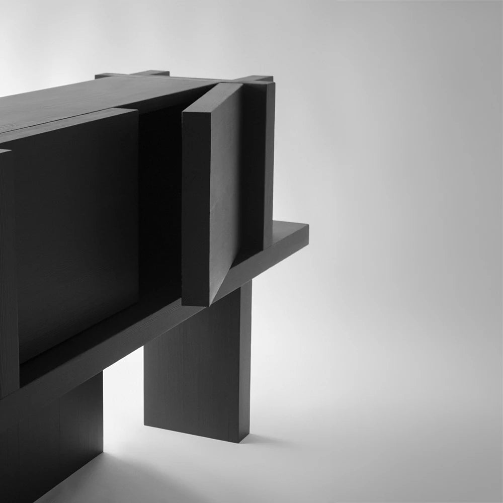 Angled detail of the Itooraba Sideboard Black by Sizar Alexis, highlighting its projecting door panels and intersecting black pine structure.