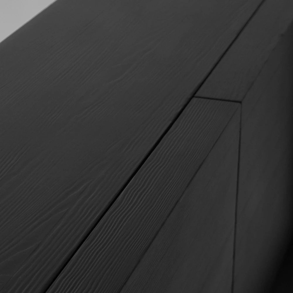 Close-up of the Itooraba Sideboard Black by Sizar Alexis, showing the meeting point of its top panels and textured pine grain.