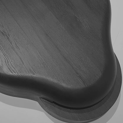 Close-up of the Lahmu Coffee Table by Sizar Alexis, revealing the black wooden surface, visible grain, and smoothly rounded tabletop edge.