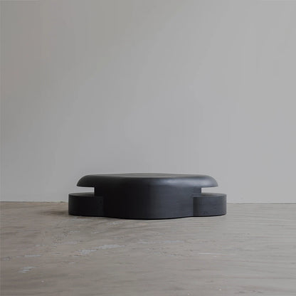 Rear view of the Lahmu Coffee Table by Sizar Alexis, revealing its extended rounded tabletop and symmetrically projecting lower sections.