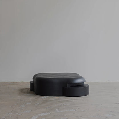 Opposite three-quarter view of the Lahmu Coffee Table by Sizar Alexis, showcasing its layered construction, curved silhouette, and dark wood grain.