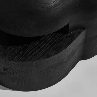 Close-up of the Lahmu Large Console Black by Sizar Alexis, revealing its curved opening, black wood grain and sculpted surfaces.