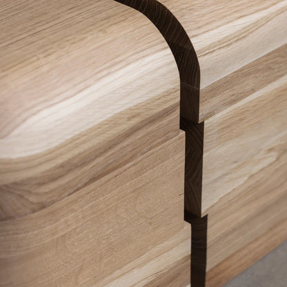 Close-up of the Lahmu Stool Natural by Sizar Alexis, highlighting curved oak grain, layered construction, and precise dark joinery.
