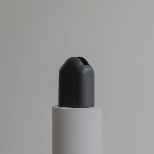 Three-quarter view of the Lahmu Vase by Sizar Alexis, revealing its rounded form, visible wood grain, and narrow upper opening.