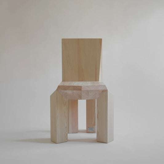 Front view of the Ode Chair Natural by Sizar Alexis, emphasizing its symmetrical structure, faceted seat edge, and visible natural grain.