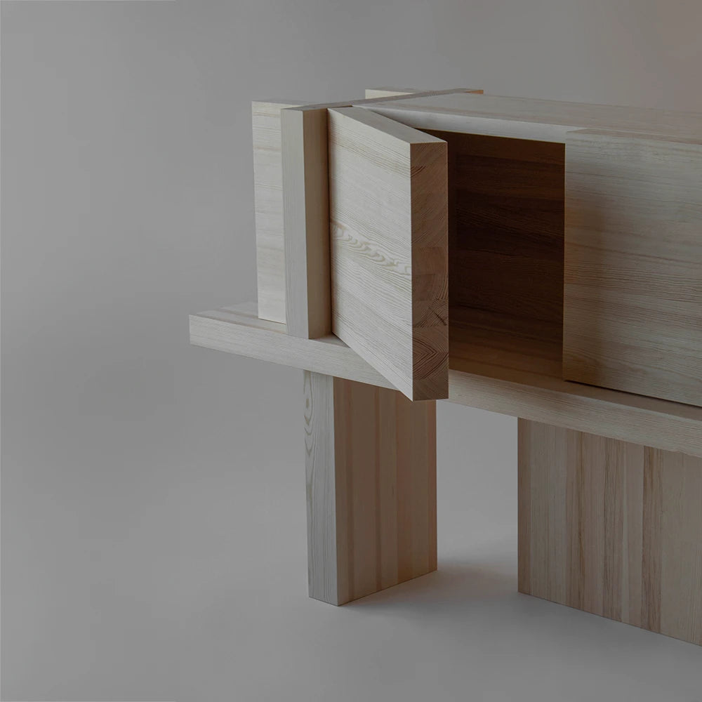 Three-quarter view of the Itooraba Sideboard Natural by Sizar Alexis with one door open, revealing its storage compartment and architectural base.