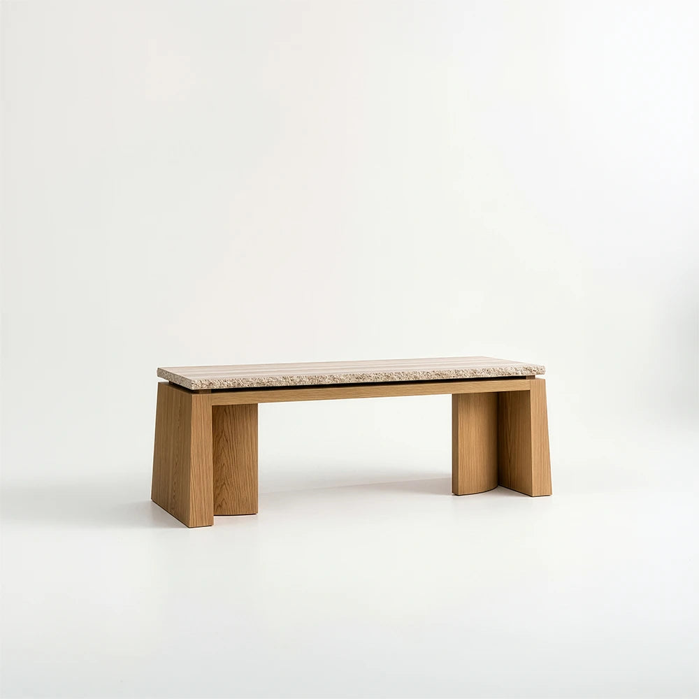 Rear three-quarter view of the Santos Desk by Studio Romell, showing its rectangular stone top, warm wooden frame and broad sculptural side supports.