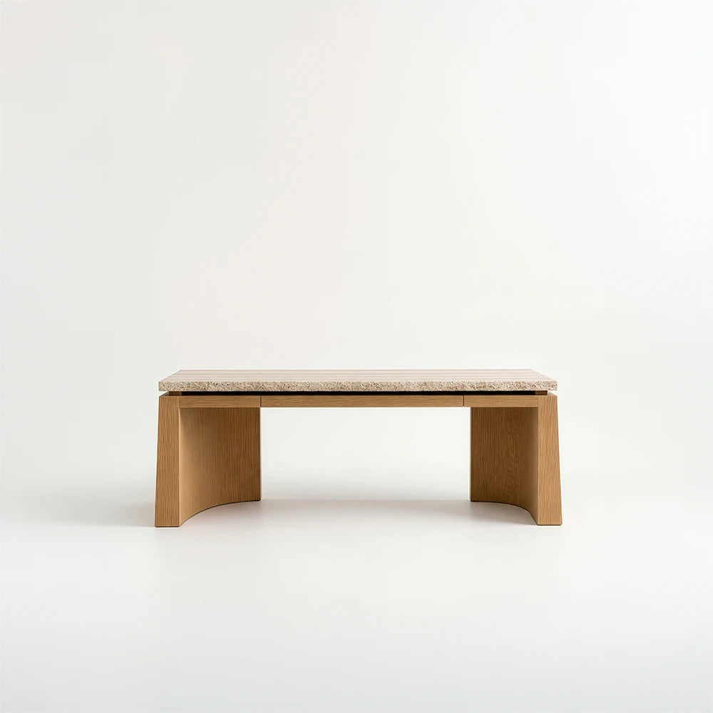 Front view of the Santos Desk by Studio Romell, showing its slim drawer fronts, pale stone desktop and symmetrical wooden supports with curved inner faces.