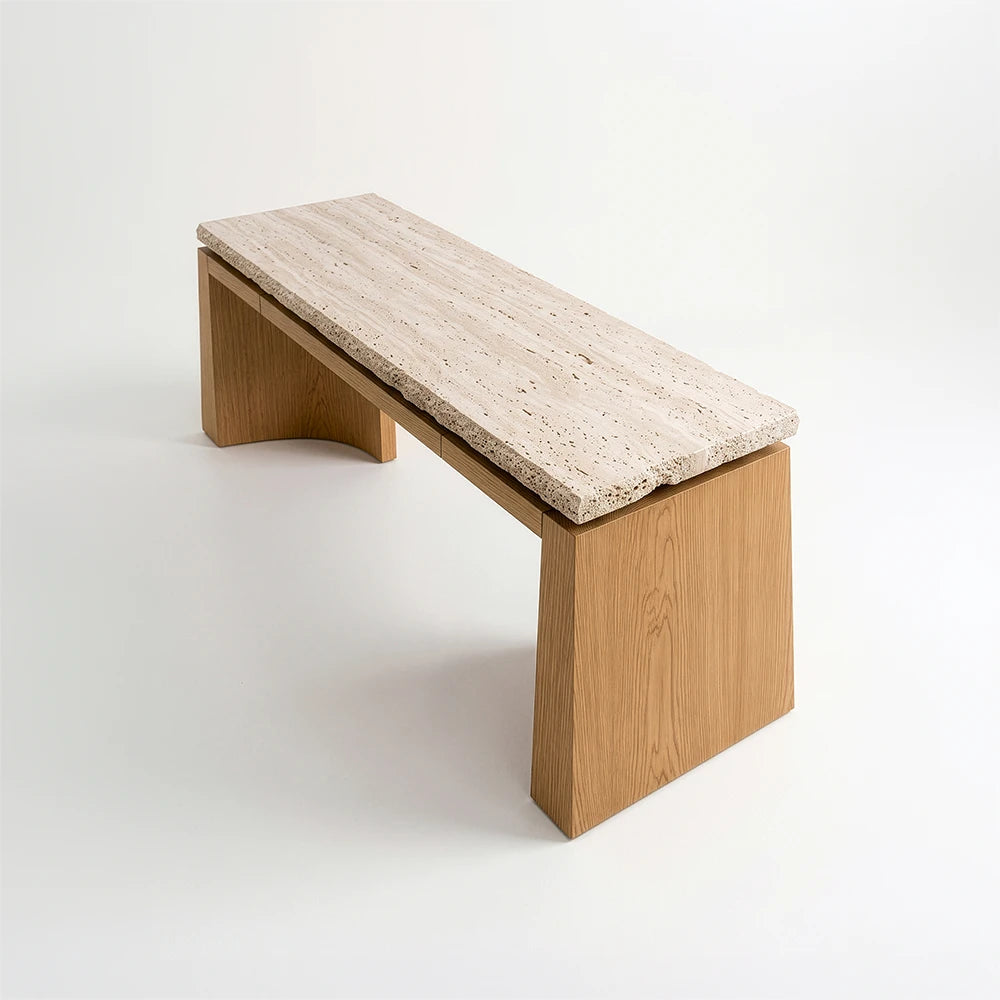 Elevated angled view of the Santos Desk by Studio Romell, revealing the pale stone desktop’s linear veining, porous edges and contrasting wooden base.