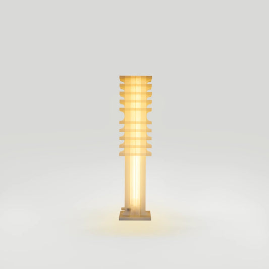 Front view of the illuminated Citadel Short Floor Light by Ultramar Studio, featuring a translucent column, layered upper section and square base.