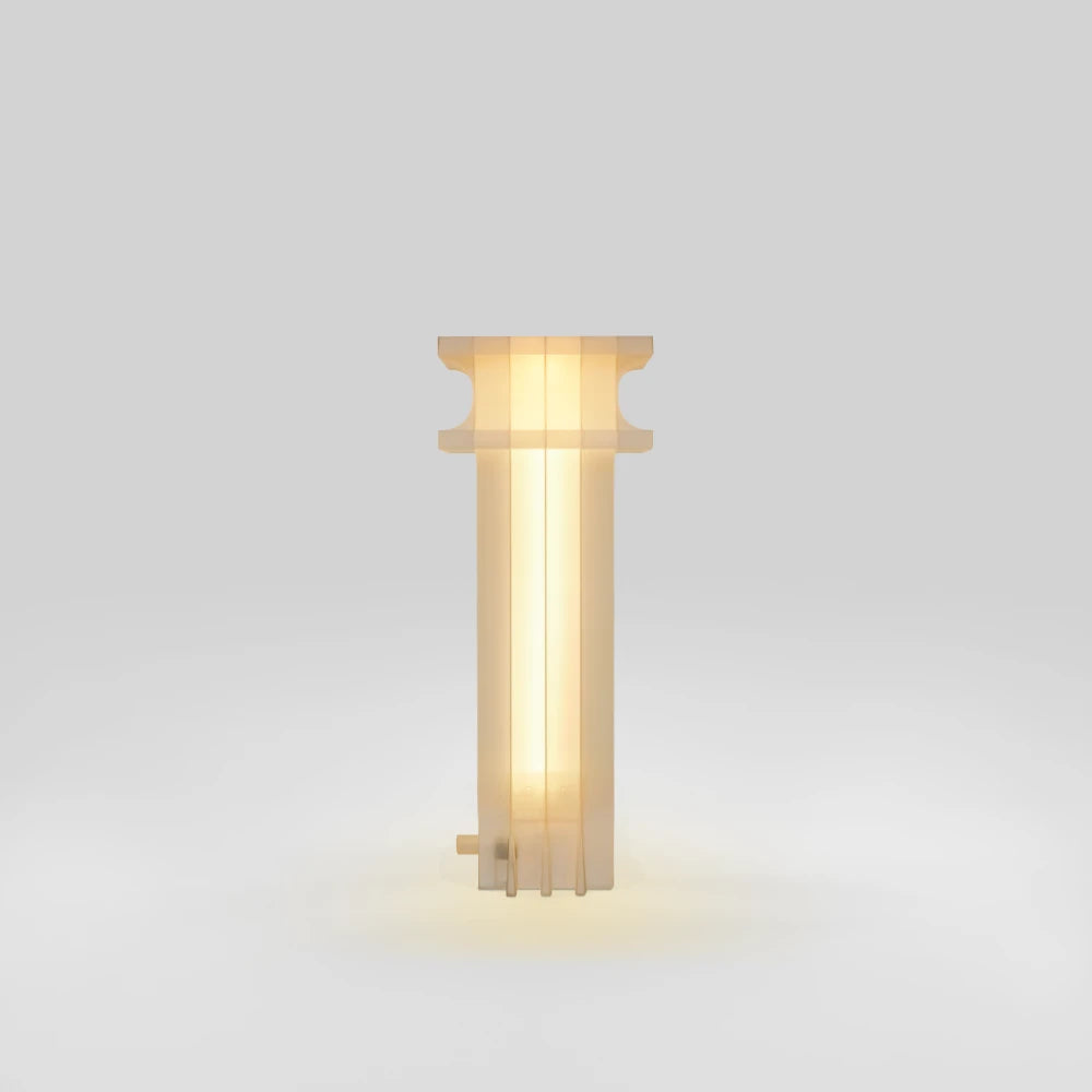 Vue de profil de la lampe Citadel Table Light allumée, par Ultramar Studio, montrant ses panneaux verticaux translucides, son profil supérieur courbe et un petit connecteur près de la base.
