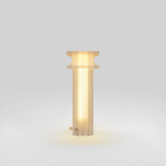 Vue de profil de la lampe Citadel Table Light allumée, par Ultramar Studio, montrant ses panneaux verticaux translucides, son profil supérieur courbe et un petit connecteur près de la base.